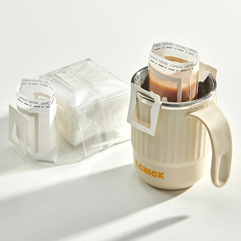 Disposable drip coffee filter bag with hanging ear design on a travel mug – lifestyle shot