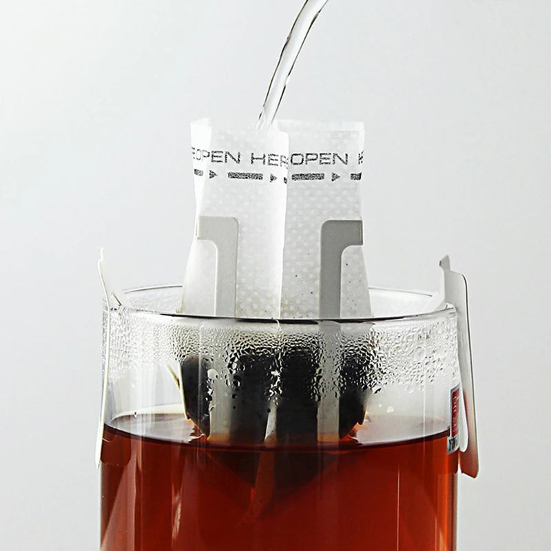 Disposable hanging ear coffee filter bag used to brew tea in a glass teapot