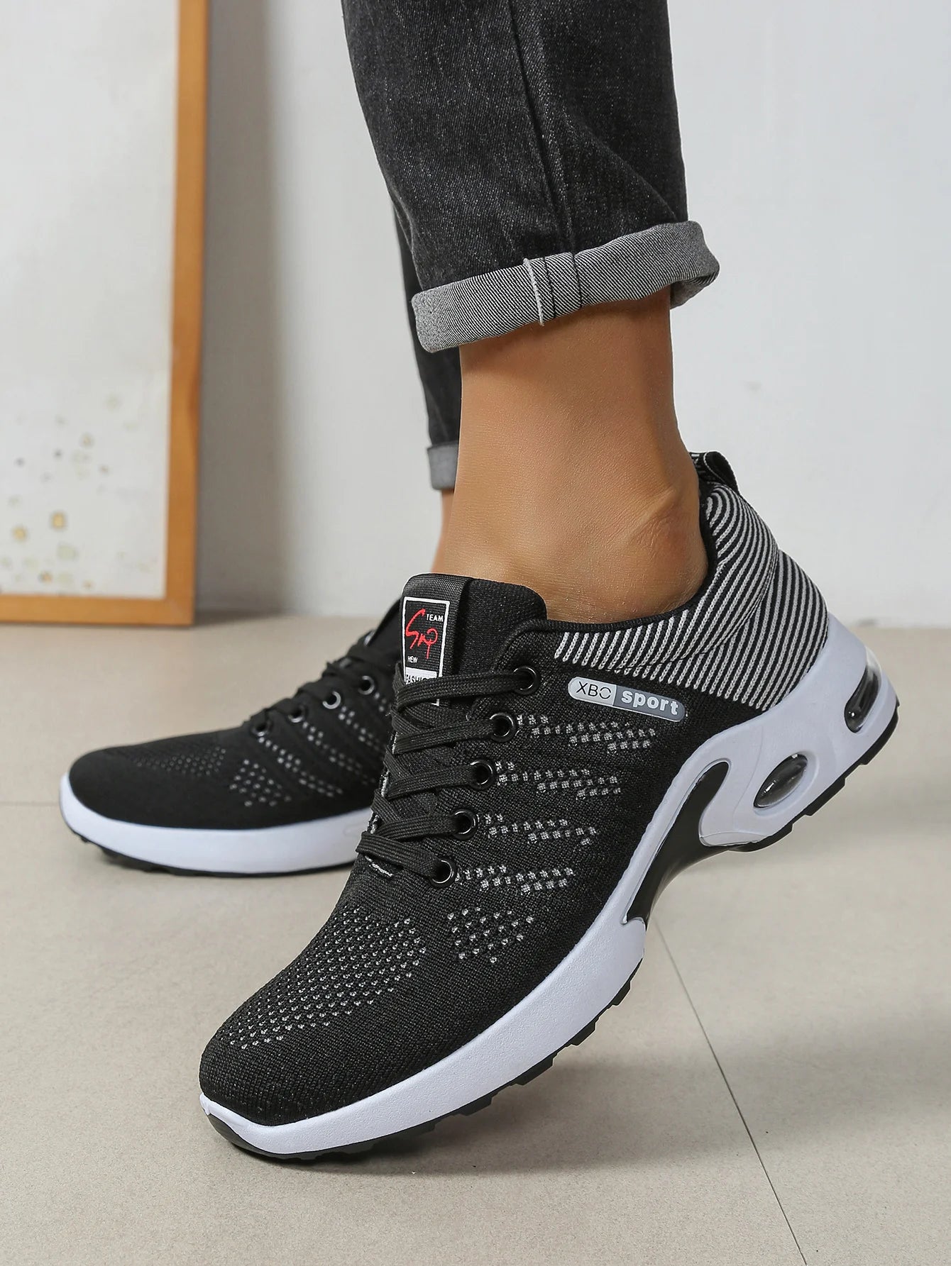 Men's black knit sneakers side profile – worn view showing air cushion sole
