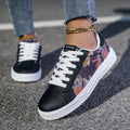 Women’s sneakers featuring a vibrant multicolour geometric side design, black toe cap, white laces, and rolled‑up jeans